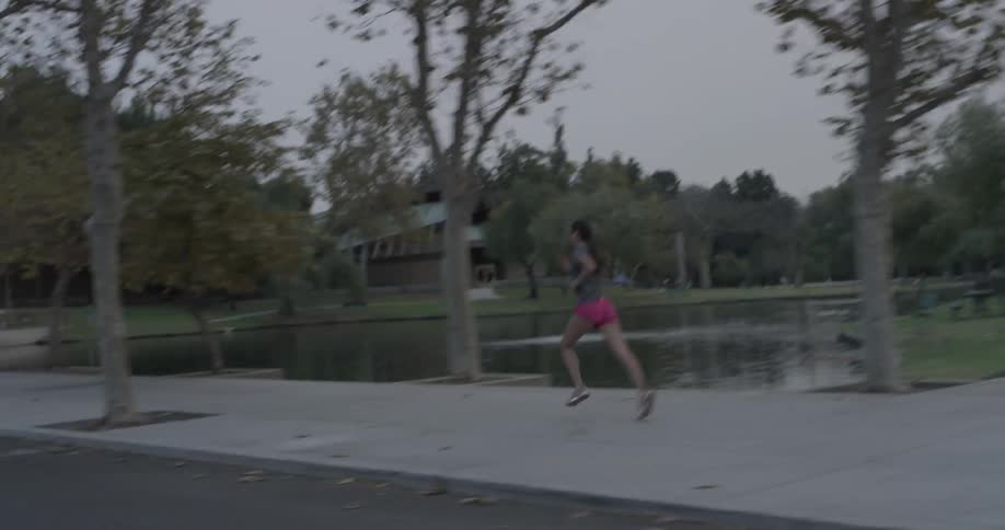 Woman runs on the sidewalk in the morning