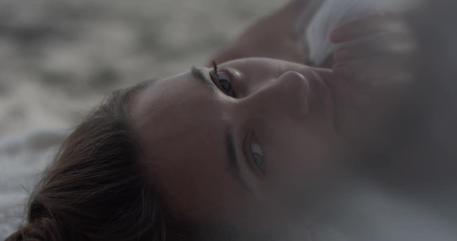 A woman is laying down and looking around