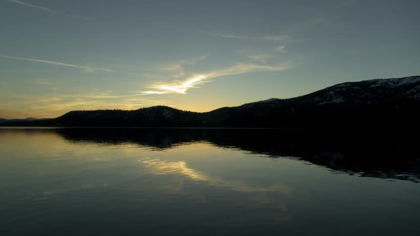 The sun and hills reflecting off of water