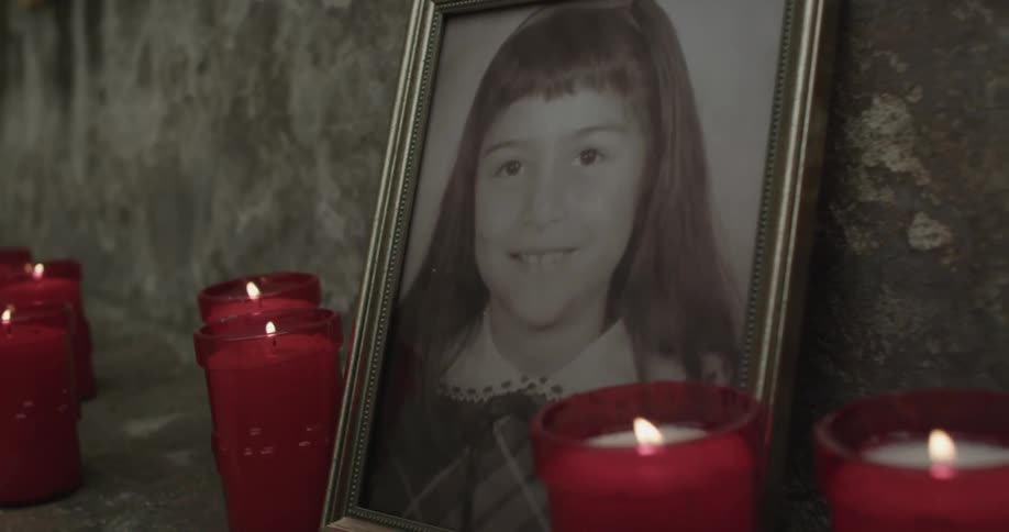 Candles burn at a tribute to a young girl