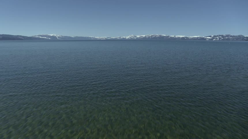 A large lake at the base of a mountain range