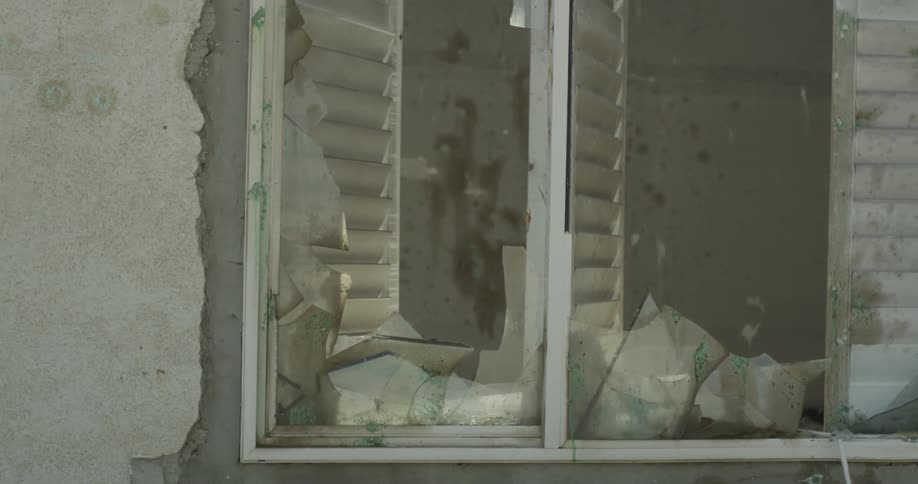 View of a broken window in a dilapidated building