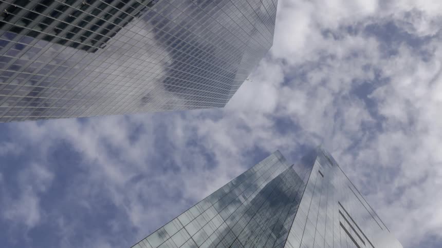 Clouds pass over tall skyscrapers
