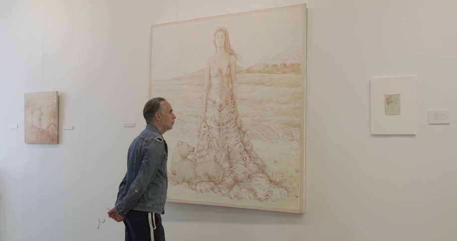 An older man looks at a painting of a woman in an art gallery
