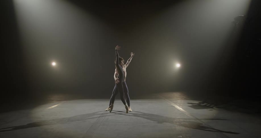 Man and woman perform a dance on stage under lights