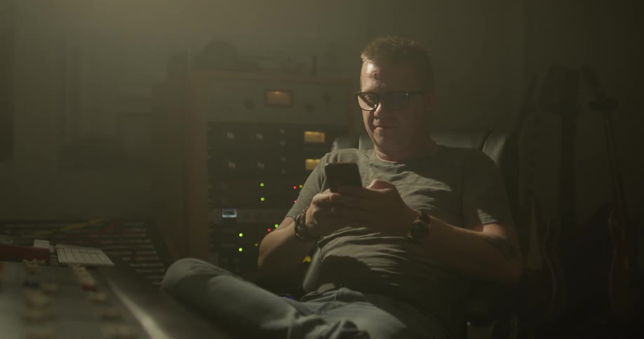 A man is sitting down while on his phone