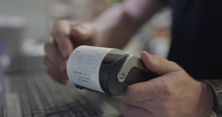 Man rips off a receipt and hands it over