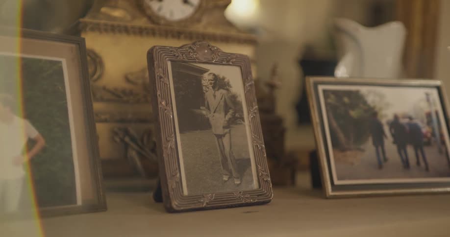 A lot of pictures that are on a mantle