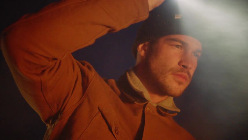 A man shining a flashlight into smoke