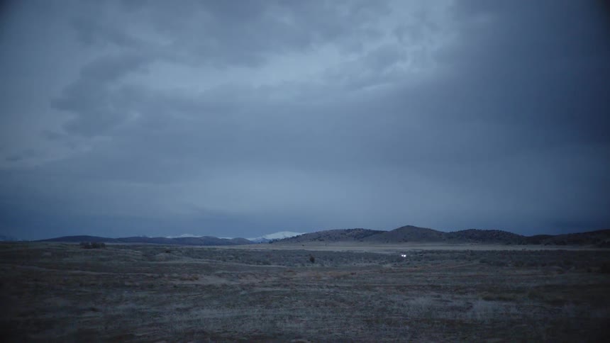 Cars drive in the distance on a rural road