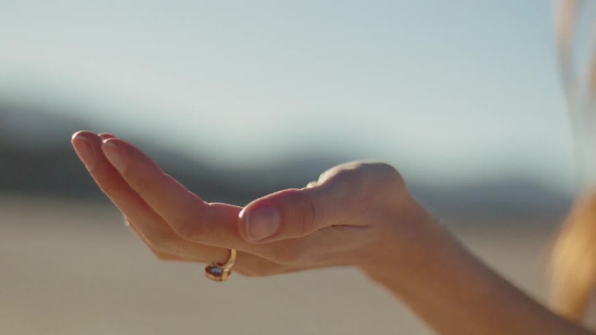 Woman cups hand up toward the sun