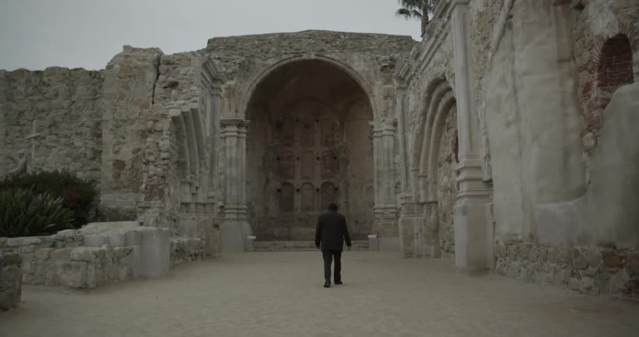 Man walking towards an old building