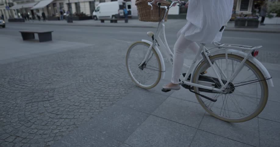 A woman is riding a bicycle outside in the city