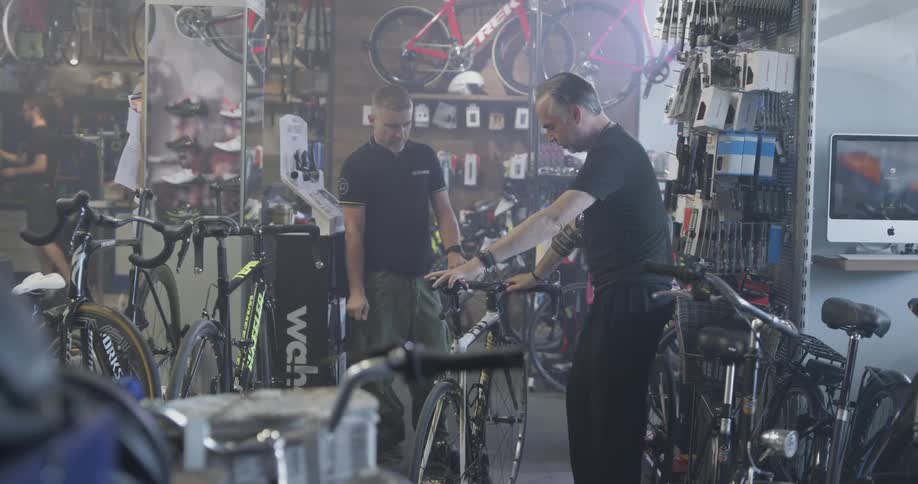 Man brings bike into shop where someone else inspects it