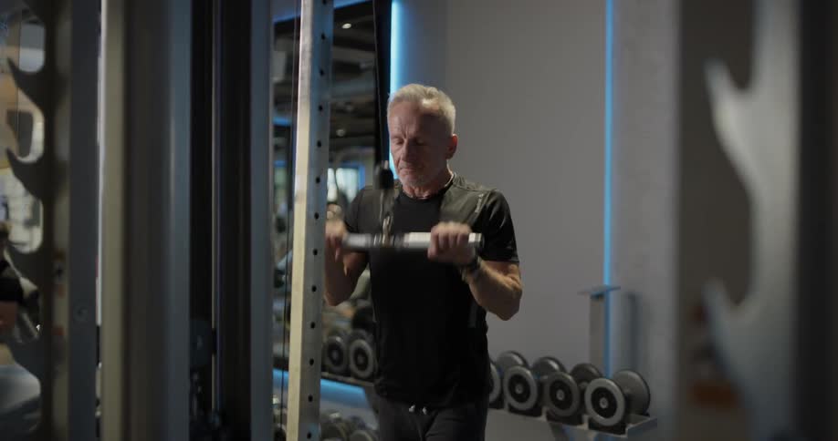 An elderly man exercises with a lateral weight machine