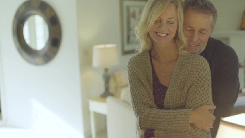 A man hugs a woman from behind