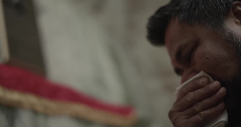 Man wiping his eyes and cries