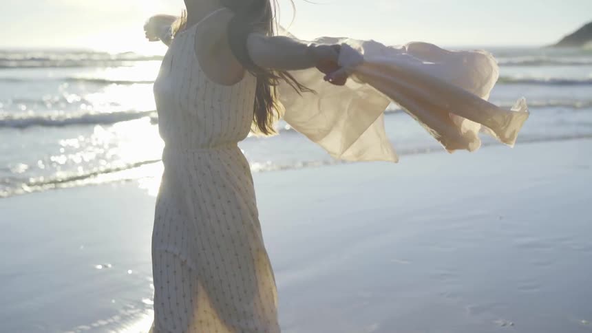 A woman is dancing by a beach