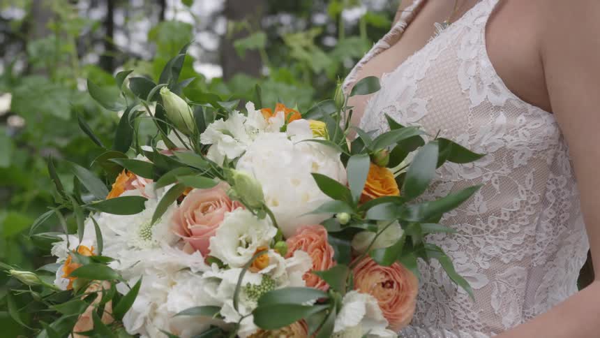 A woman in a white dress holding a bouquet of flowers
