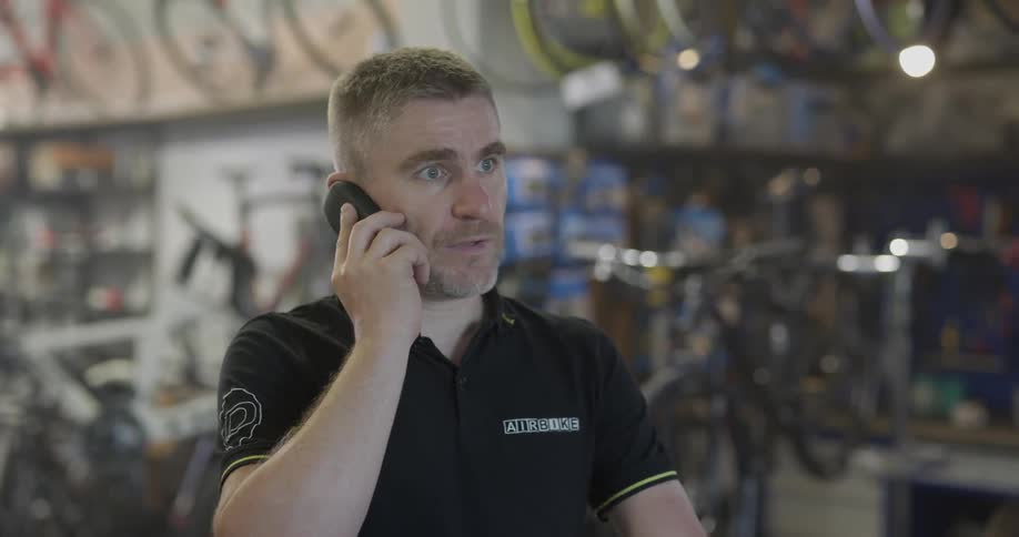 Man talking on a cell phone in a bicycle shop