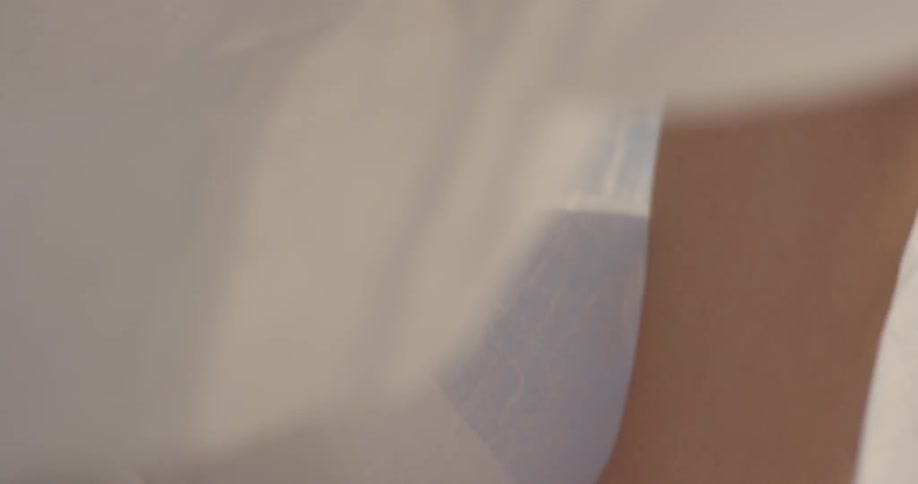 Woman waves filmy white fabric over her head
