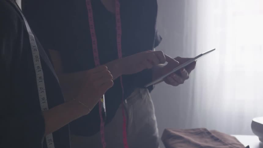 Two people reading things on a tablet