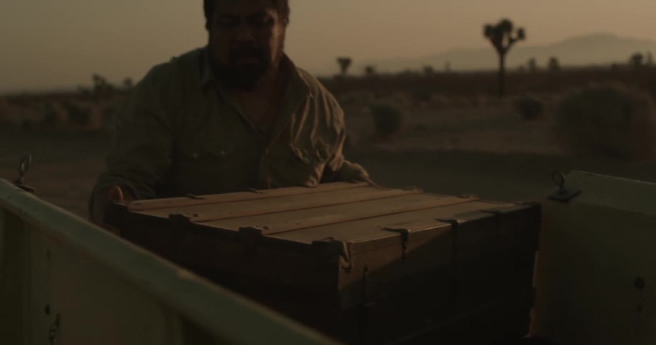 Man lifting a heavy crate in a desert