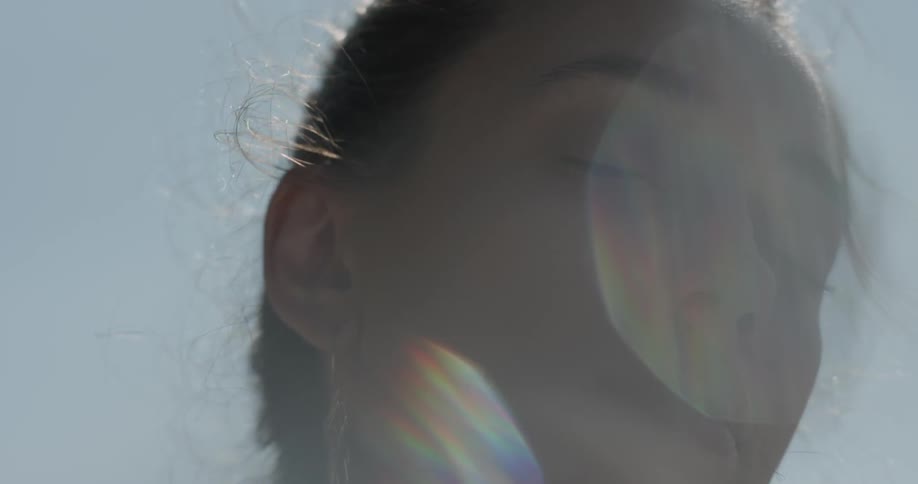 Woman framed by the sun looks down
