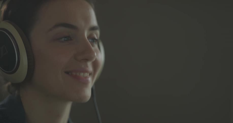 Woman puts on headphones and head bobs to music