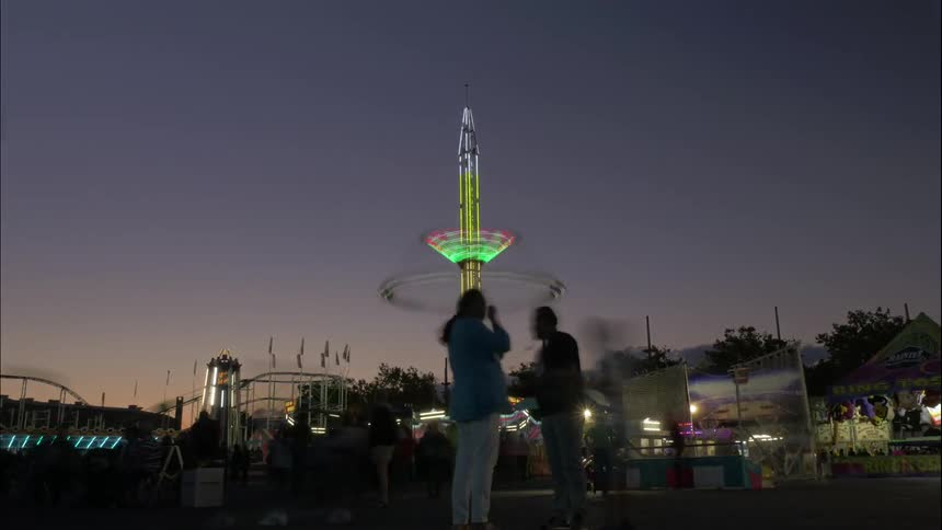 A crowd moving throughout an amusement park