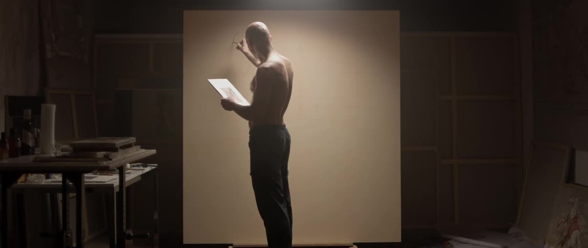 A man is drawing on a canvas