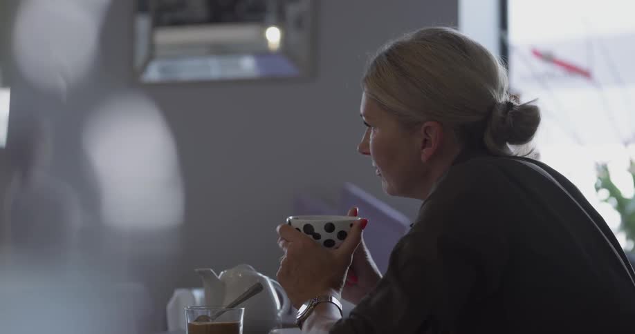 Woman talks while sipping a drink