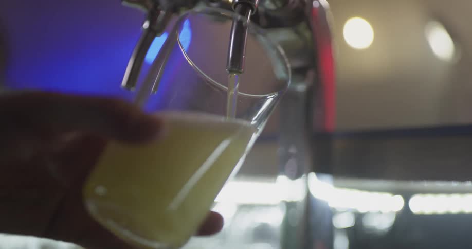 Glass being washed and filled with beer at a bar