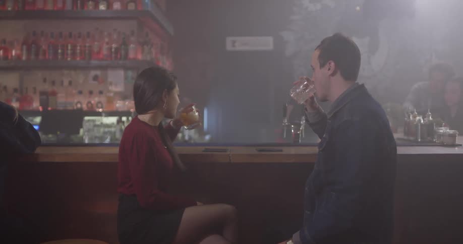 A man and woman are having drinks and talking