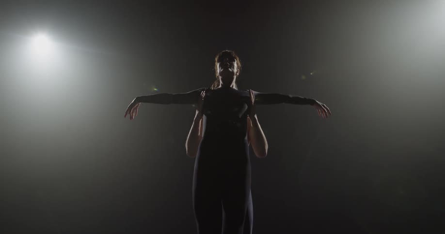 Two dancers perform under the bright lights
