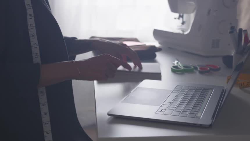 A woman writing and typing in a room