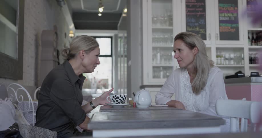 Two women are sitting at a table and talking