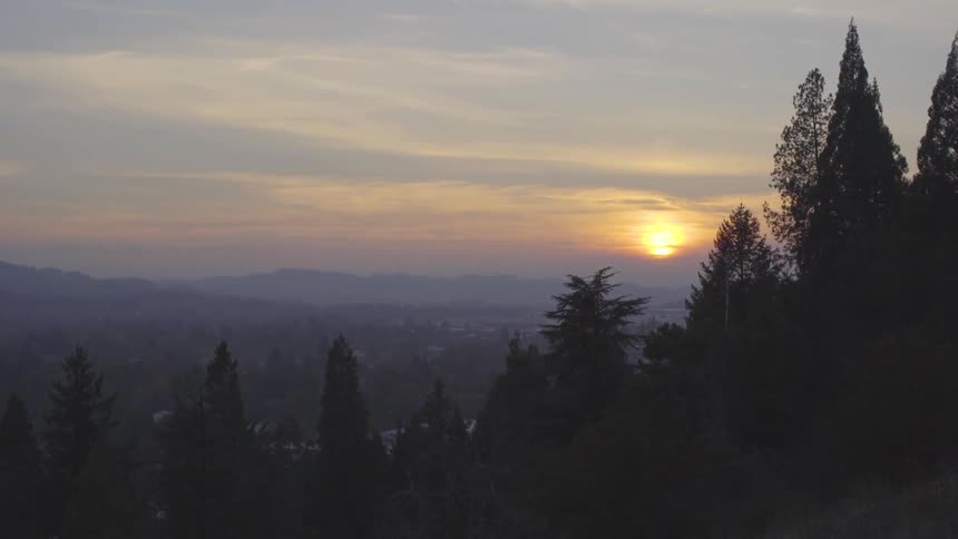 Sun sets on the horizon behind the clouds