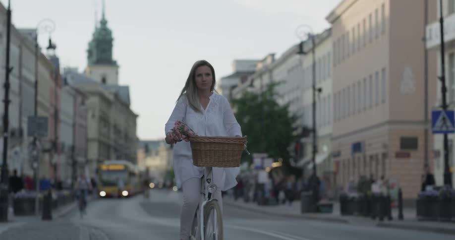 Woman pedals a bike down a busy city street