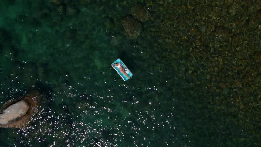 A woman lounging on top of the ocean water