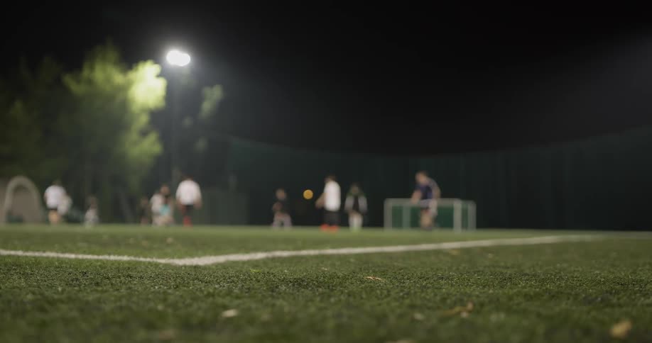 A group of men playing soccer at night