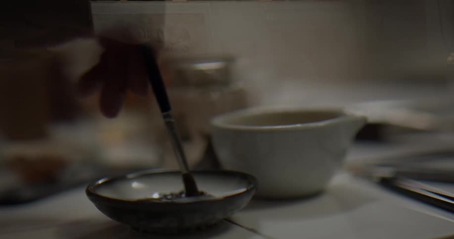 A person mixing paints at a table
