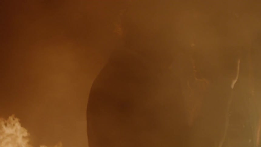 A man and woman are standing close by a fire