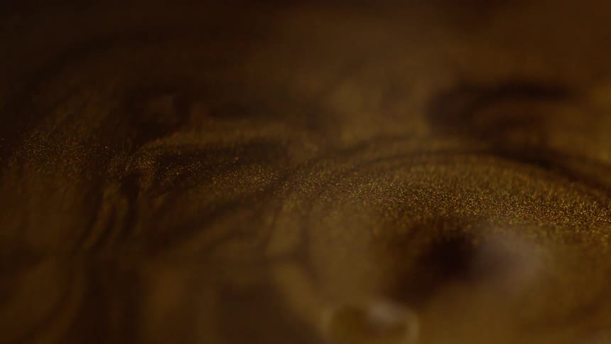 Gold drops fall into the liquid