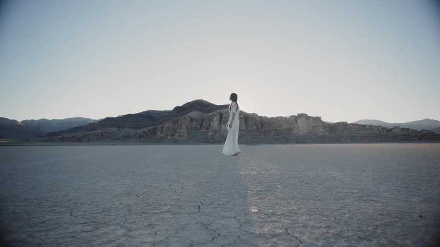 A woman walking in a dry desert