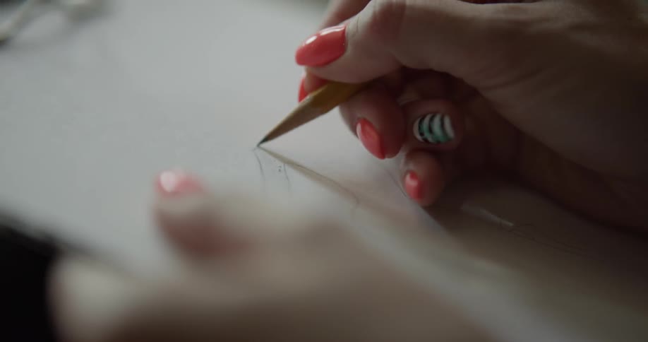 A woman draws with a pencil and large eraser