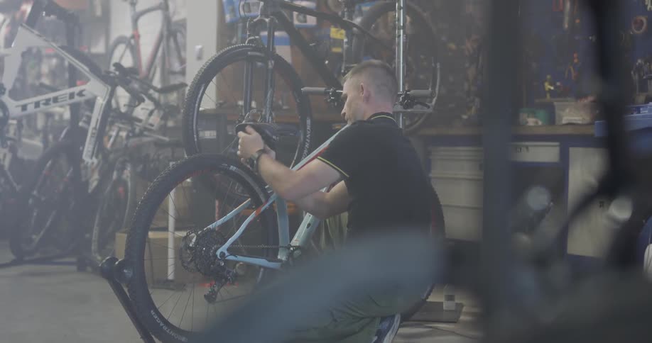 A man is working on placing a seat on a bike