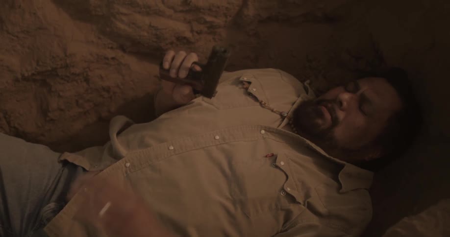 Man laying on the ground holding a gun