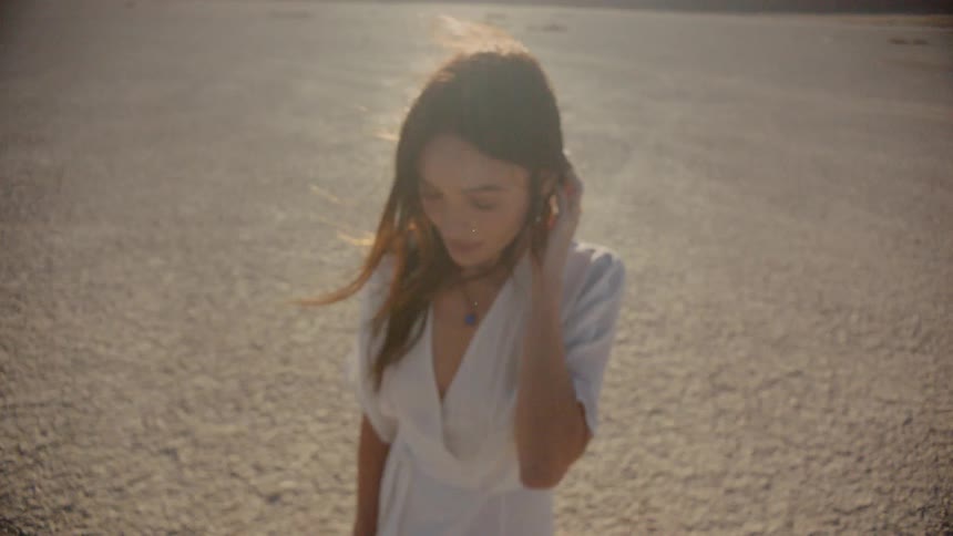 Woman stands in the desert on a sunny and windy day