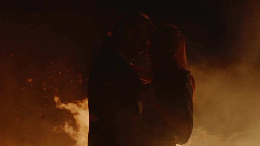 A couple embracing surrounded by fire